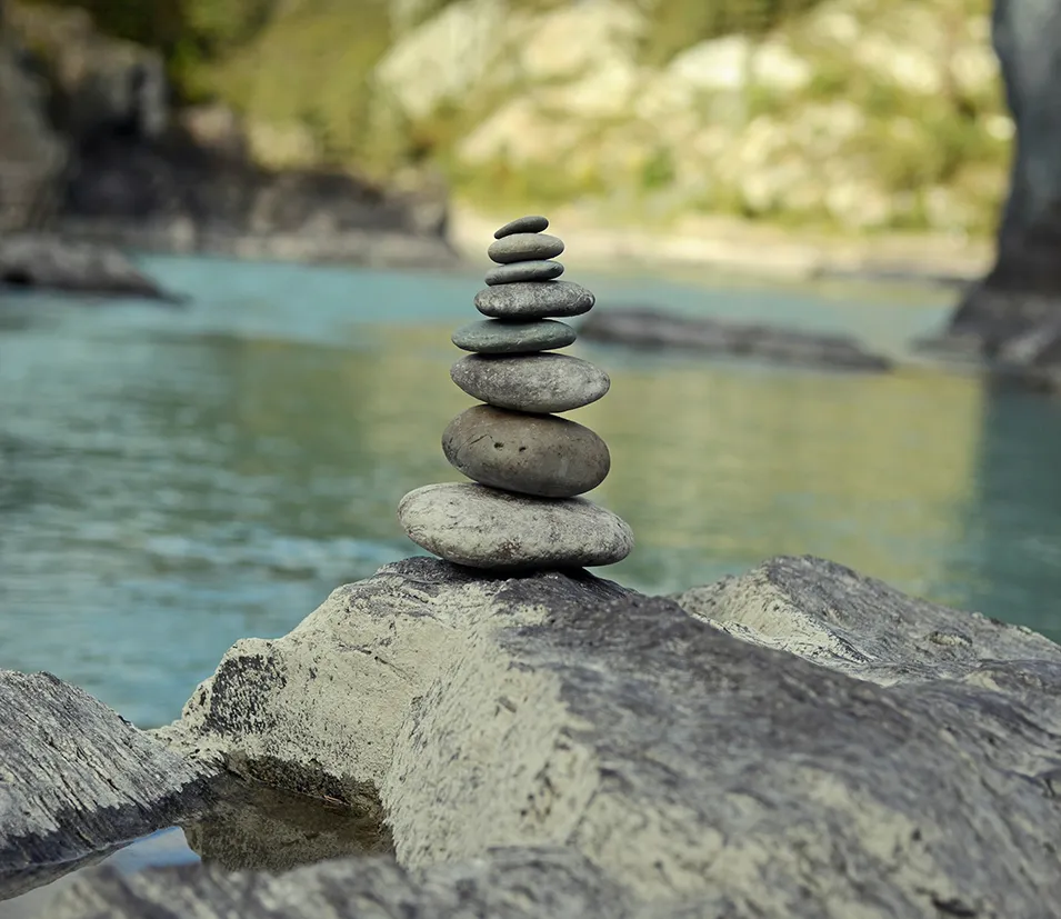 Balanced stones by river representing the adhd coaching and support benefits in Carlisle and Cumbria